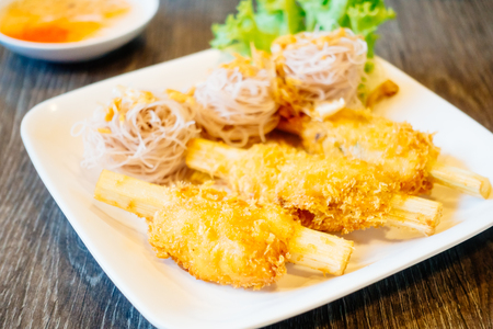 Fried shrimp with sugar cane in white plate with sweet sauceの写真素材