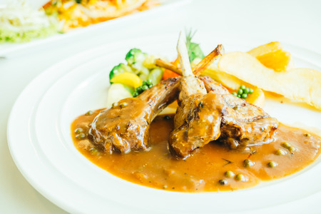 Grilled lamb chops meat with french fries and vegetable in white plate in white plateの写真素材
