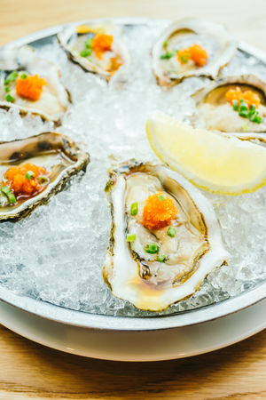 Raw and fresh oyster shell with lemon on iceの写真素材