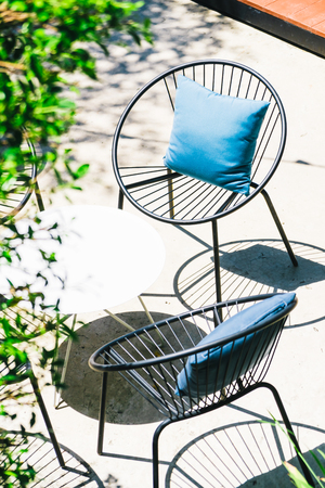 Patio with Pillow on chair and table set in outdoor gardenの写真素材