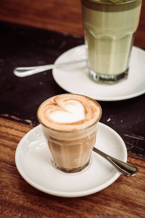Hot latte coffee cup on table in cafe shop - Vintage Filterの写真素材