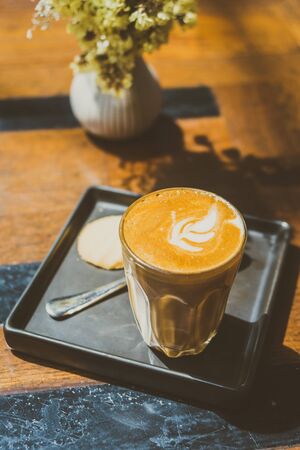 Hot latte coffee cup on table in shop and cafe - Vintage Filterの写真素材