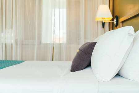 Comfortable pillow on bed decoration bedroom interior with light lamp