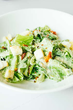 Grilled caesar salad with fresh vegetable in white plate - Healthy food styleの写真素材