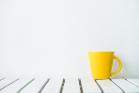 Yellow coffee cup on table with copy spaceの写真素材