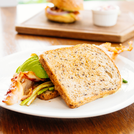 Sandwich with avocado bacon and asparagus in white plateの写真素材