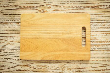 Wood cutting board on wooden background with copy space