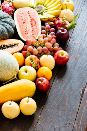 Assorted and mixed fruits on wooden background with copy space - Healthy food conceptの写真素材