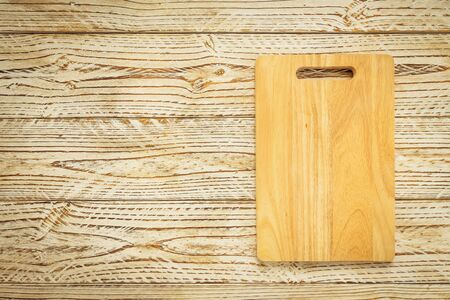 Wood cutting board on wooden background with copy spaceの写真素材