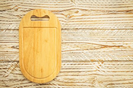 Wood cutting board on wooden background with copy space