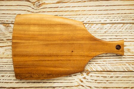 Wood cutting board on wooden background with copy space
