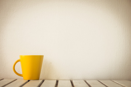 Yellow coffee cup on table with copy spaceの写真素材
