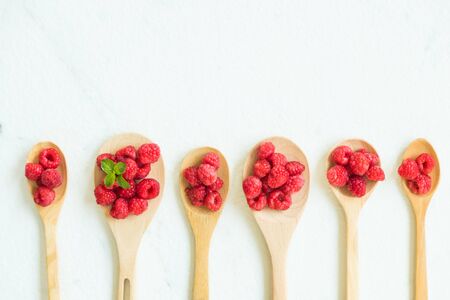 Red rasberries fruit in spoon on tableの写真素材