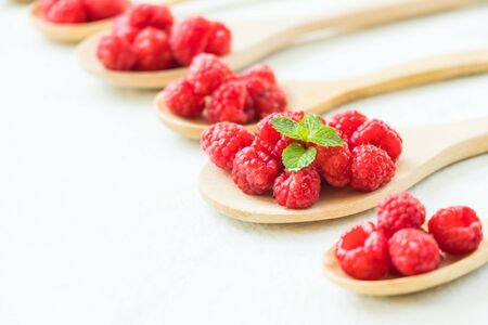 Red rasberries fruit in spoon on table