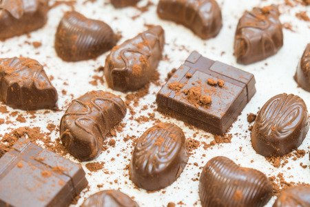 Sweet dessert with dark chocolate pieces and cocoa powder on white stone background