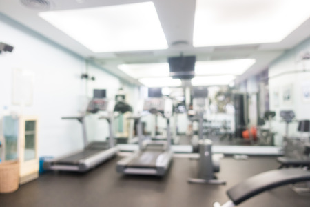 Abstract blur and defocused sport fitness equipment in gym interior for background