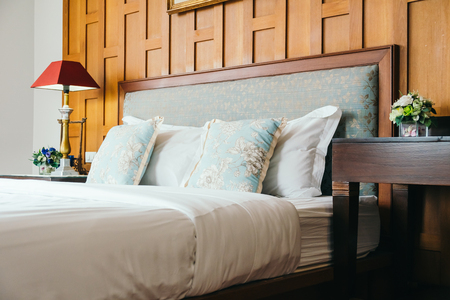 Comfort pillow on bed with light lamp decoration in hotel bedroom interiorの写真素材