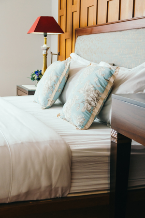 Comfort pillow on bed with light lamp decoration in hotel bedroom interiorの写真素材