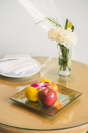 Welcome fruit in hotel bedroom with white flower in vaseの写真素材