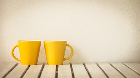 Yellow coffee cup on table with copy spaceの写真素材