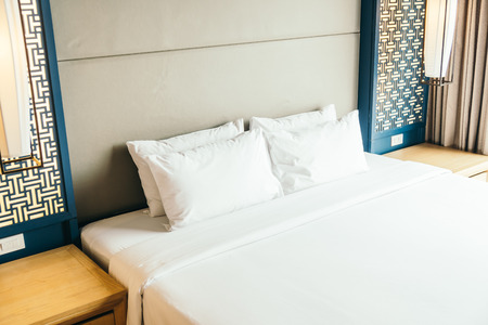White comfortable pillow on bed decoration in hotel bedroom interiorの写真素材