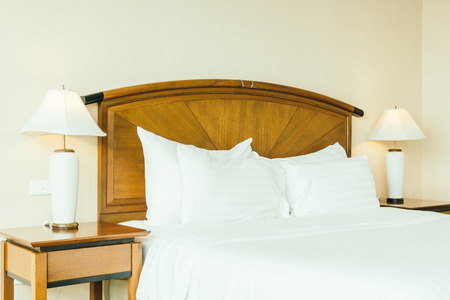 White comfortable pillow on bed decoration in hotel bedroom interiorの写真素材