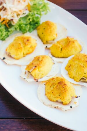 Grilled shell with butter and garlic in white plateの写真素材