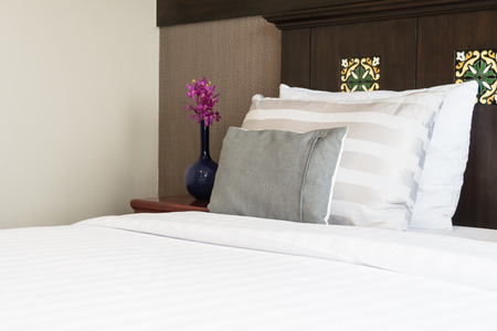 Comfort pillow on bed with light lamp decoration in hotel bedroom interiorの写真素材