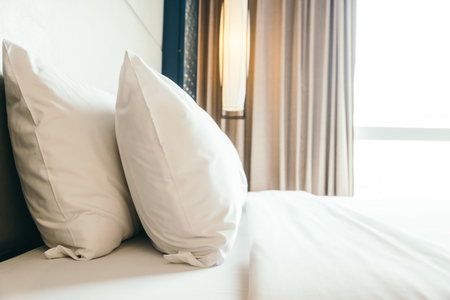 White comfortable pillow on bed decoration in bedroom interiorの写真素材