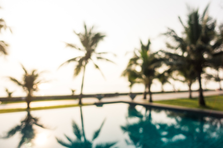 Abstract blur outdoor swimming pool with coconut palm tree in hotel and resort for backgroundの写真素材