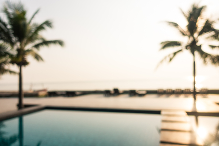 Abstract blur outdoor swimming pool with coconut palm tree in hotel and resort for backgroundの写真素材