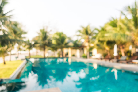 Abstract blur outdoor swimming pool with coconut palm tree in hotel and resort for backgroundの写真素材