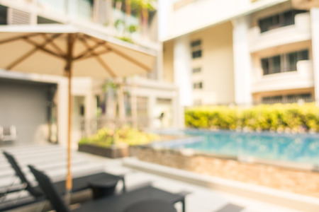 Abstract blur and defocus outdoor swimming pool with umbrella and chair in hotel and resort for backgroundの写真素材
