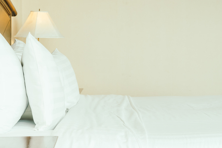 White comfortable pillow on bed decoration in hotel bedroom interiorの写真素材