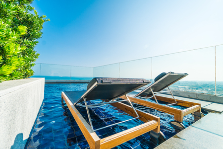 Chair and bed around swimming pool in hotel and resortの写真素材