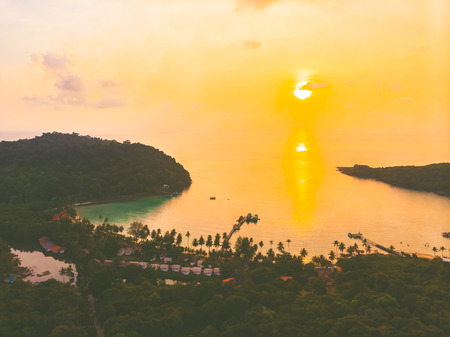 Aerial view of sea and beach with coconut palm tree on island at sunset timeの写真素材