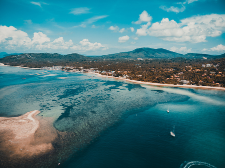 Beautiful aerial view of beach and sea with many tree and white cloud on blue sky in koh samui island for vacation and travelの写真素材