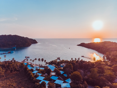Aerial view of sea and beach with coconut palm tree on island at sunset timeの写真素材