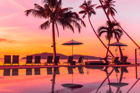 Beautiful outdoor view with umbrella and chair around swimming pool in luxury hotel and resort at sunrise time for travel and vacationのeditorial素材