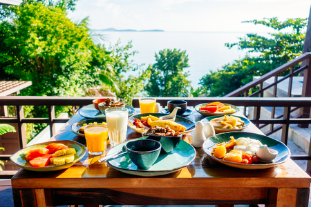 Healthy breakfast set with egg bacon pancakes orange juice milk bread coffee and other on wooden tableの写真素材