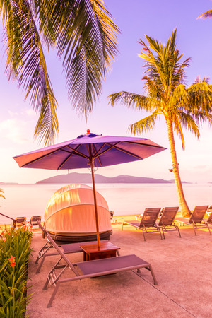 Beautiful outdoor view with umbrella and chair around swimming pool in luxury hotel and resort at sunrise time for travel and vacationのeditorial素材