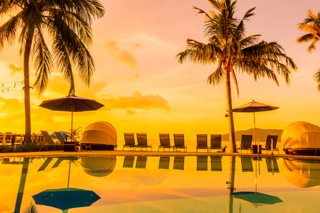 Beautiful outdoor view with umbrella and chair around swimming pool in luxury hotel and resort at sunrise time for travel and vacationのeditorial素材