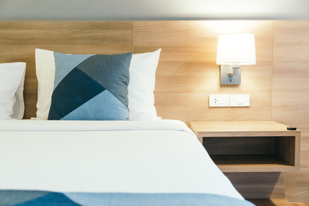 Comfortable white pillow on bed decoration in hotel bedroom interiorの写真素材