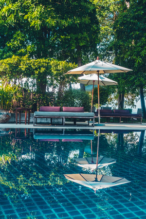 Beautiful luxury outdoor swimming pool with umbrella and chair in hotel and resort for travel and vacationのeditorial素材