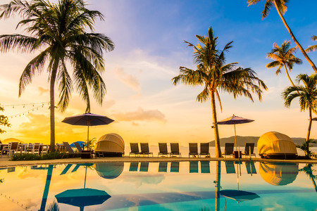 Beautiful outdoor view with umbrella and chair around swimming pool in luxury hotel and resort at sunrise time for travel and vacationのeditorial素材