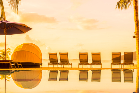 Beautiful outdoor view with umbrella and chair around swimming pool in luxury hotel and resort at sunrise time for travel and vacationのeditorial素材