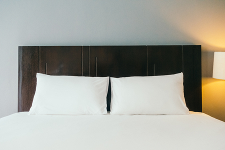 White comfortable pillow on bed decoration in hotel bed roomの写真素材
