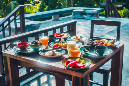 Healthy breakfast set with egg bacon pancakes orange juice milk bread coffee and other on wooden tableの写真素材