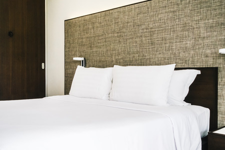 White comfortable pillow on bed decoration interior of hotel bedroom