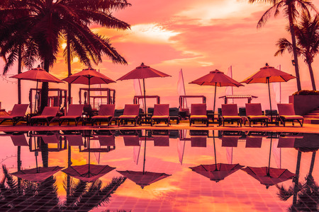 Beautiful luxury outdoor swimming pool with umbrella and chair in hotel and resort for travel and...
